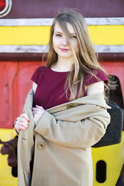 Woman in beige coat and red dress — Stock Photo, Image