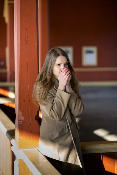 Femme en manteau beige réchauffant son souffle — Photo