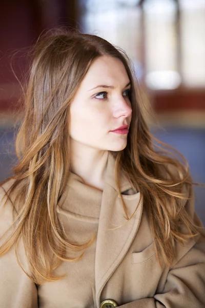 Vrouw in beige jas met verbazing kijken — Stockfoto
