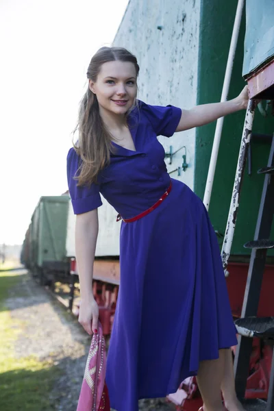 Donna tenere sulle scale del treno con sciarpa — Foto Stock