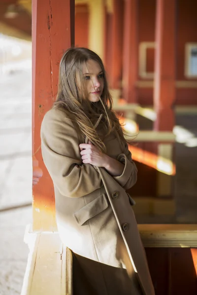 Kvinna i päls känner sig kall på station — Stockfoto