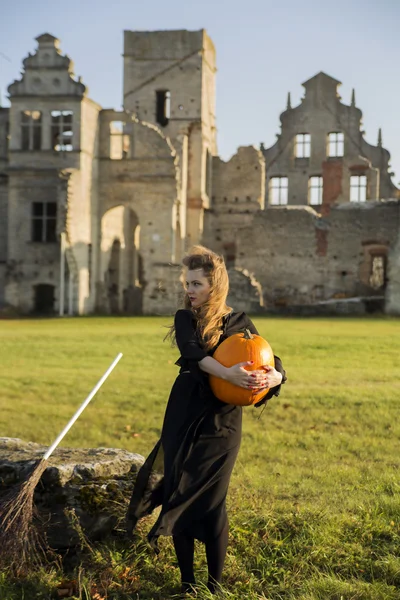Witch with pale skin embraces pumpkin — Stock Photo, Image