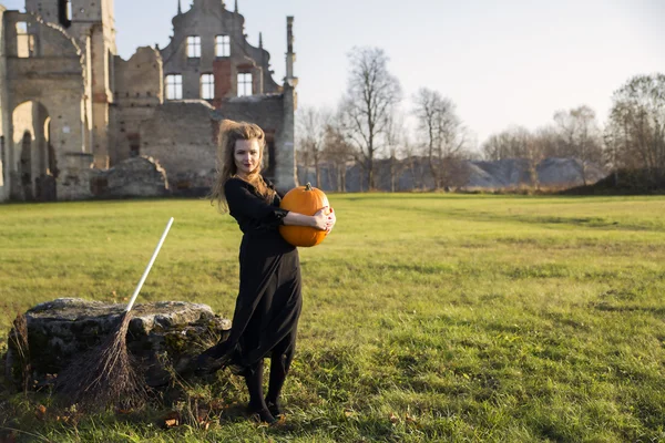 Witch with pale skin hold heavy pumpkin — Stock Photo, Image