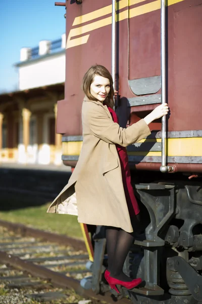 Femme en manteau et chariot à la gare — Photo