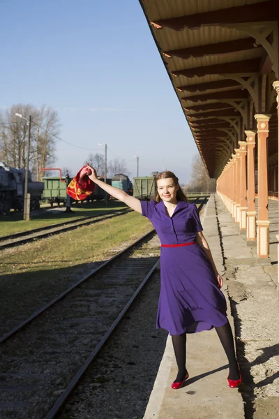 Frau im fliederfarbenen Kleid wählt am Bahnhof — Stockfoto