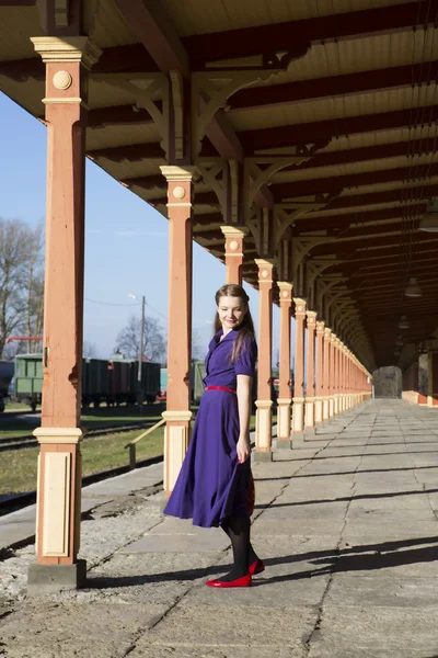 Donna alla stazione ferroviaria in abito lilla — Foto Stock