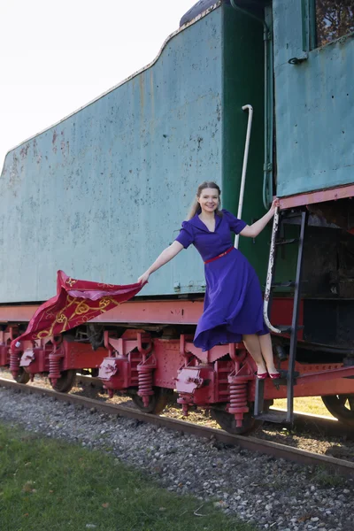 Woman at lilac dress on moving train — Stock Photo, Image