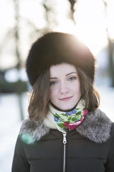 Mildly smiling woman with a mild sunshine behind her — Stock Photo, Image