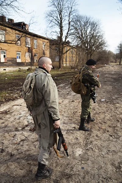 Two armed men looking around in the village — Stock Photo, Image