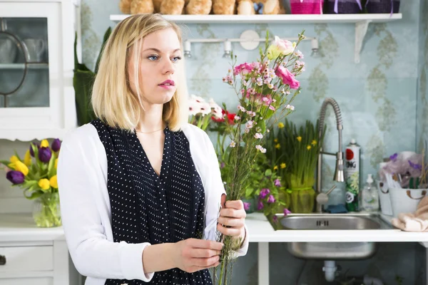 Girl with the flowers in her hand thinks about the order — Stock Photo, Image