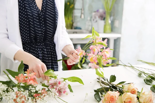 En florist kombinerar blommor — Stockfoto
