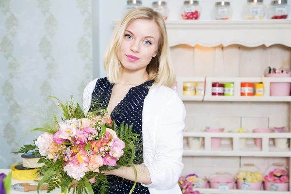 Cute smiling blond woman with a tender boquet gift