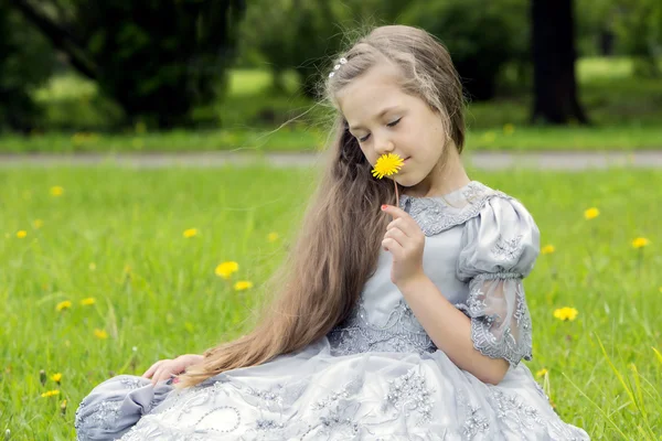 Al bambino piacciono i fiori nel parco. — Foto Stock