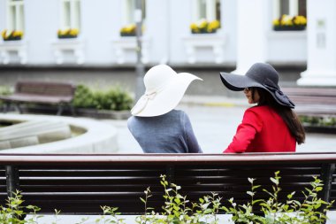 Eski moda bayanlar bankta sohbet