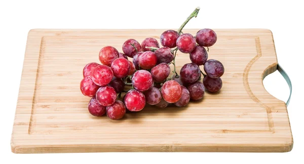 Red grapes on chopping board — Stock Photo, Image