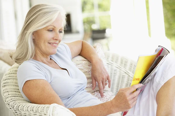 Seniorin liest draußen — Stockfoto