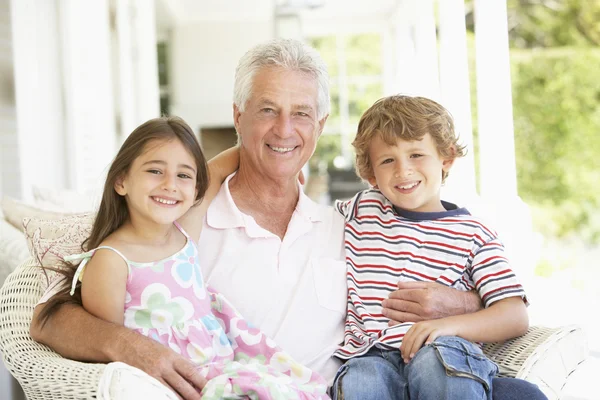 Дедушка с внуками дома — стоковое фото