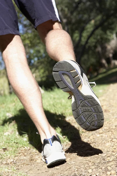 Männerfüße joggen auf Waldweg — Stockfoto