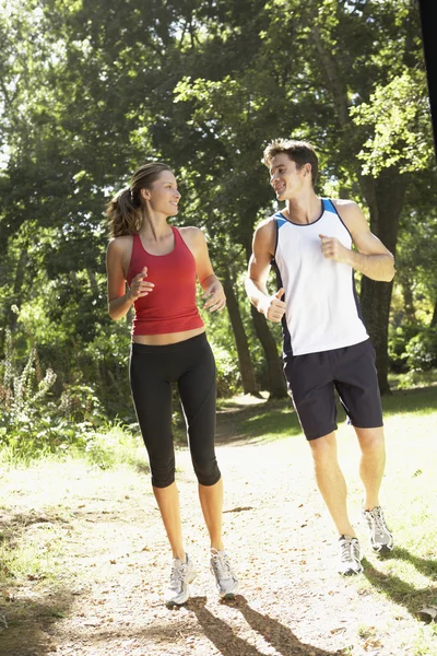 Pareja corriendo a lo largo del camino del bosque — Foto de Stock