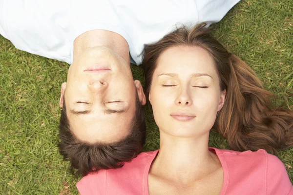 Uzavřeno pár ležící na trávě s očima — Stock fotografie