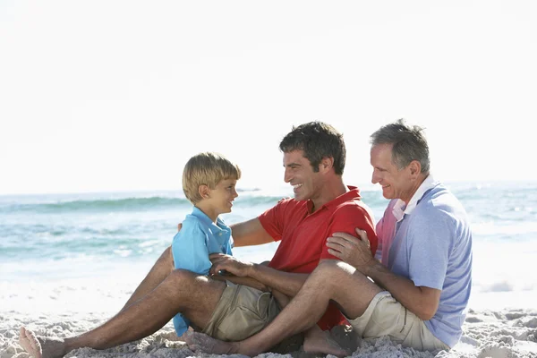 Grootvader, zoon en kleinzoon op strand — Stockfoto