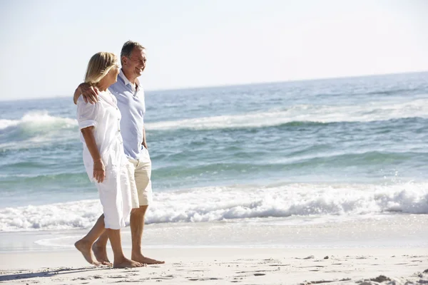 Senior paar wandelen langs strand — Stockfoto