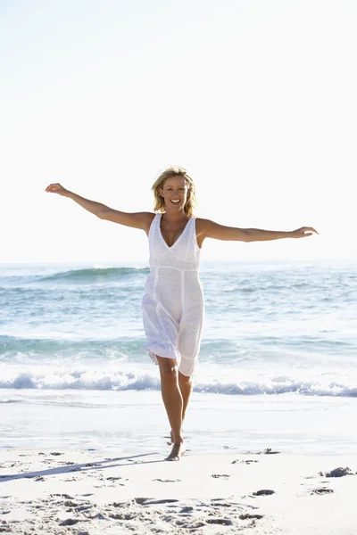 Junge Frau läuft am Strand entlang — Stockfoto