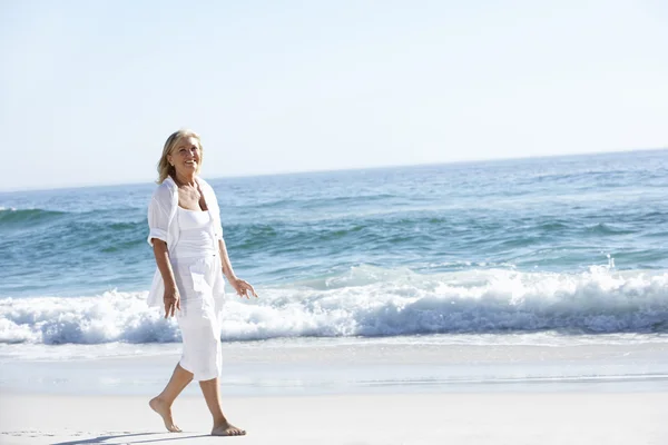 Vrouw wandelen langs Sandy Beach — Stockfoto