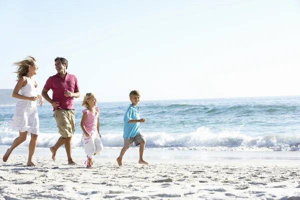 Familie loopt langs het zandstrand — Stockfoto