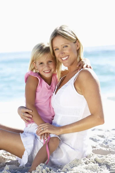 Mãe e filha sentadas na praia — Fotografia de Stock