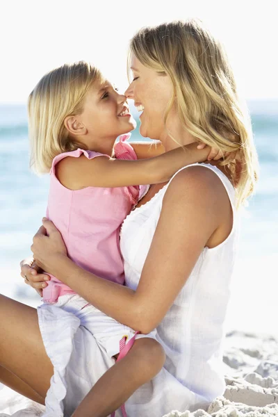Mutter und Tochter sitzen am Strand — Stockfoto