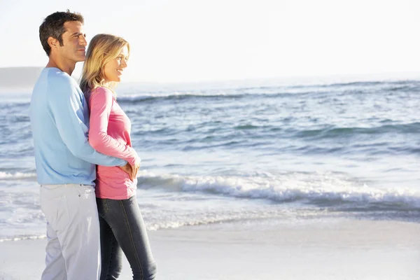 Pareja joven de pie en la playa — Foto de Stock