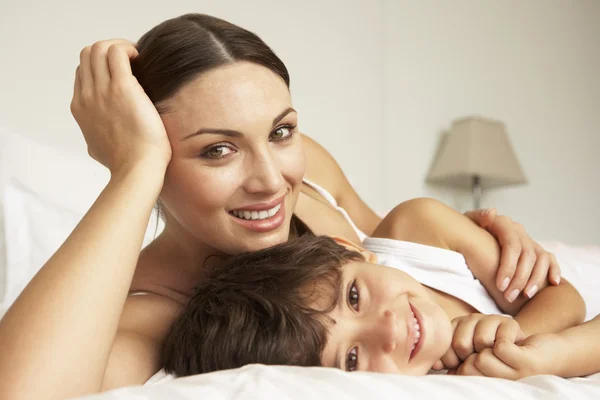 Mãe e filho relaxando na cama — Fotografia de Stock