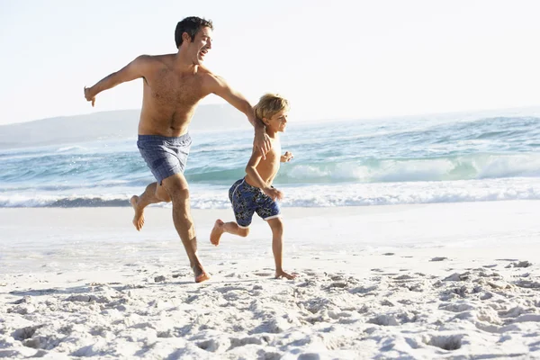 Vader en zoon loopt langs de strand — Stockfoto