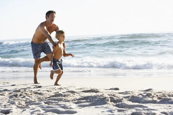 Padre e figlio che corrono lungo la spiaggia — Foto Stock