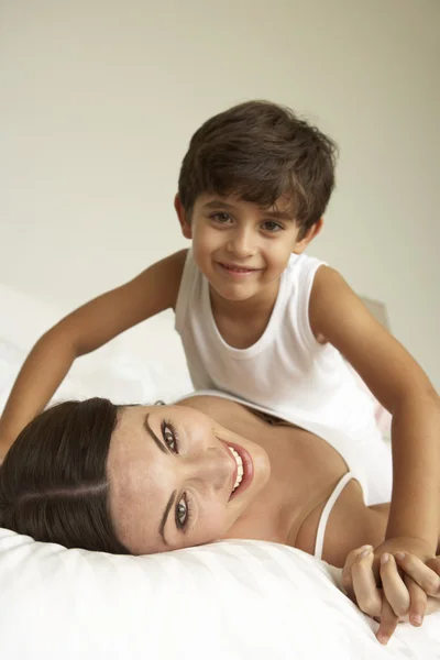 Mãe e filho relaxando na cama — Fotografia de Stock