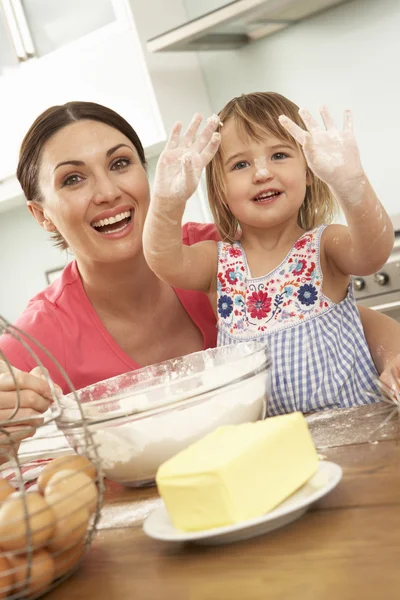 Chica ayudando a la madre a hornear pasteles —  Fotos de Stock