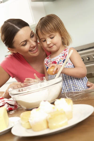 Chica ayudando a la madre a hornear pasteles — Foto de Stock