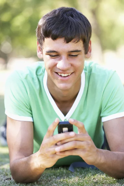 Pojke läsa meddelande på mobiltelefon — Stockfoto