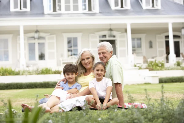 Evinin önünde Çimenlikte oturan aile — Stok fotoğraf