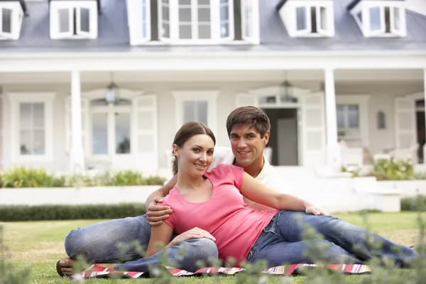 家の外の芝生の上に座っているカップル — ストック写真