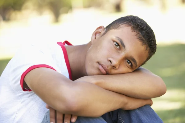 Infeliz adolescente menino sentado no parque — Fotografia de Stock