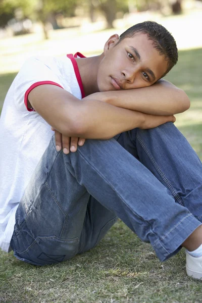 不幸を探して公園に座っている男子生徒 — ストック写真