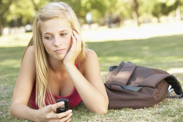 Недовольный студент с мобильным телефоном в парке — стоковое фото