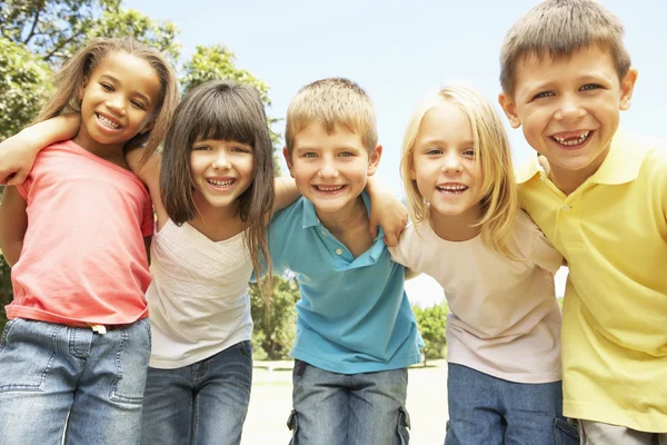 Groep kinderen ontspannen In Park Rechtenvrije Stockfoto's