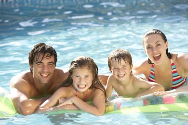 Family Relaxing In Swimming Pool clipart