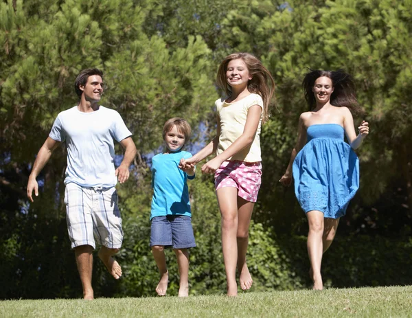 Family Running Through Field — Stockfoto