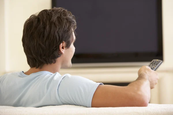 Чоловік дивиться широкоекранний телевізор — стокове фото