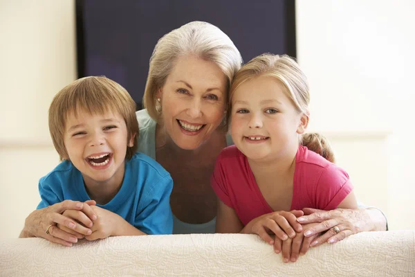 Babičky a vnoučata sledovat širokoúhlé Tv — Stock fotografie