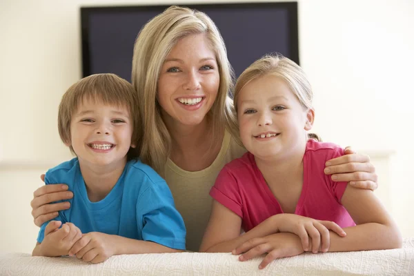 Mãe e filhos assistindo TV em casa — Fotografia de Stock